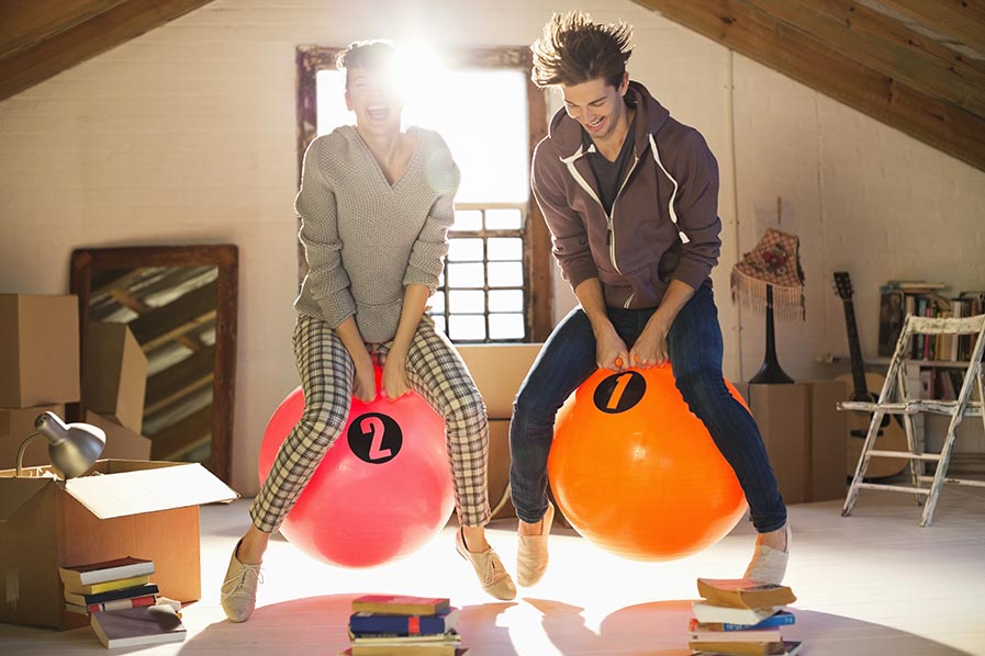 Couple jumping on exercise balls together