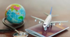 Stethoscope , passport document, airplane and globe. Healthcare and travel insurance concept