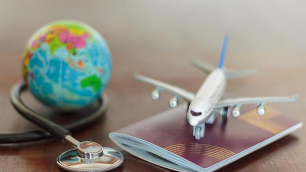 Stethoscope , passport document, airplane and globe. Healthcare and travel insurance concept